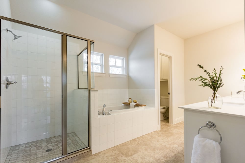 tiled bathroom with tub and shower