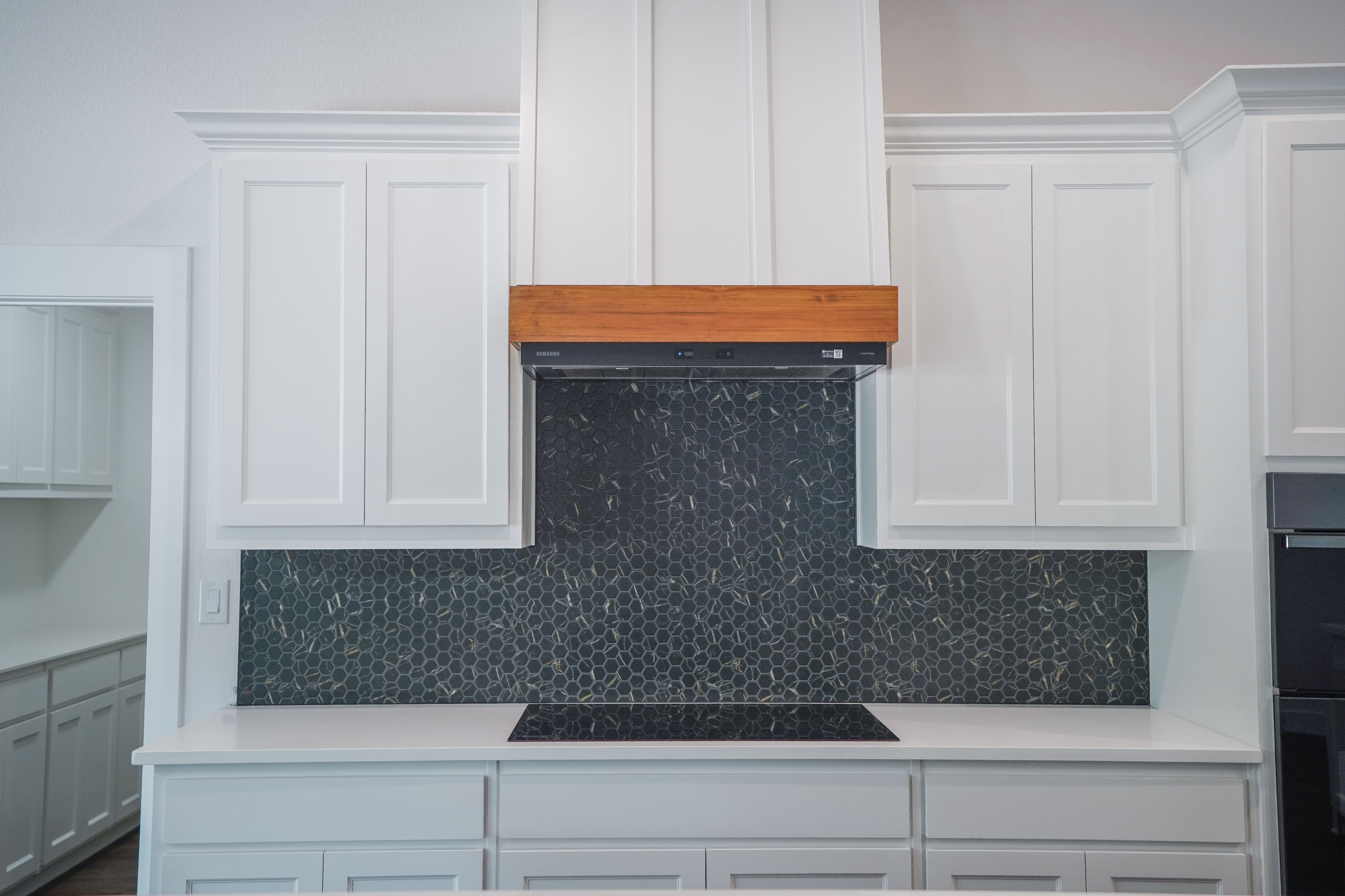 Backsplash Black_White Cabinets_Wood Hood