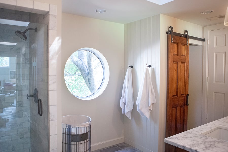 Bathroom Design (Custom Texas Homes): Pine Barn Door and Oval Window in Custom Bath