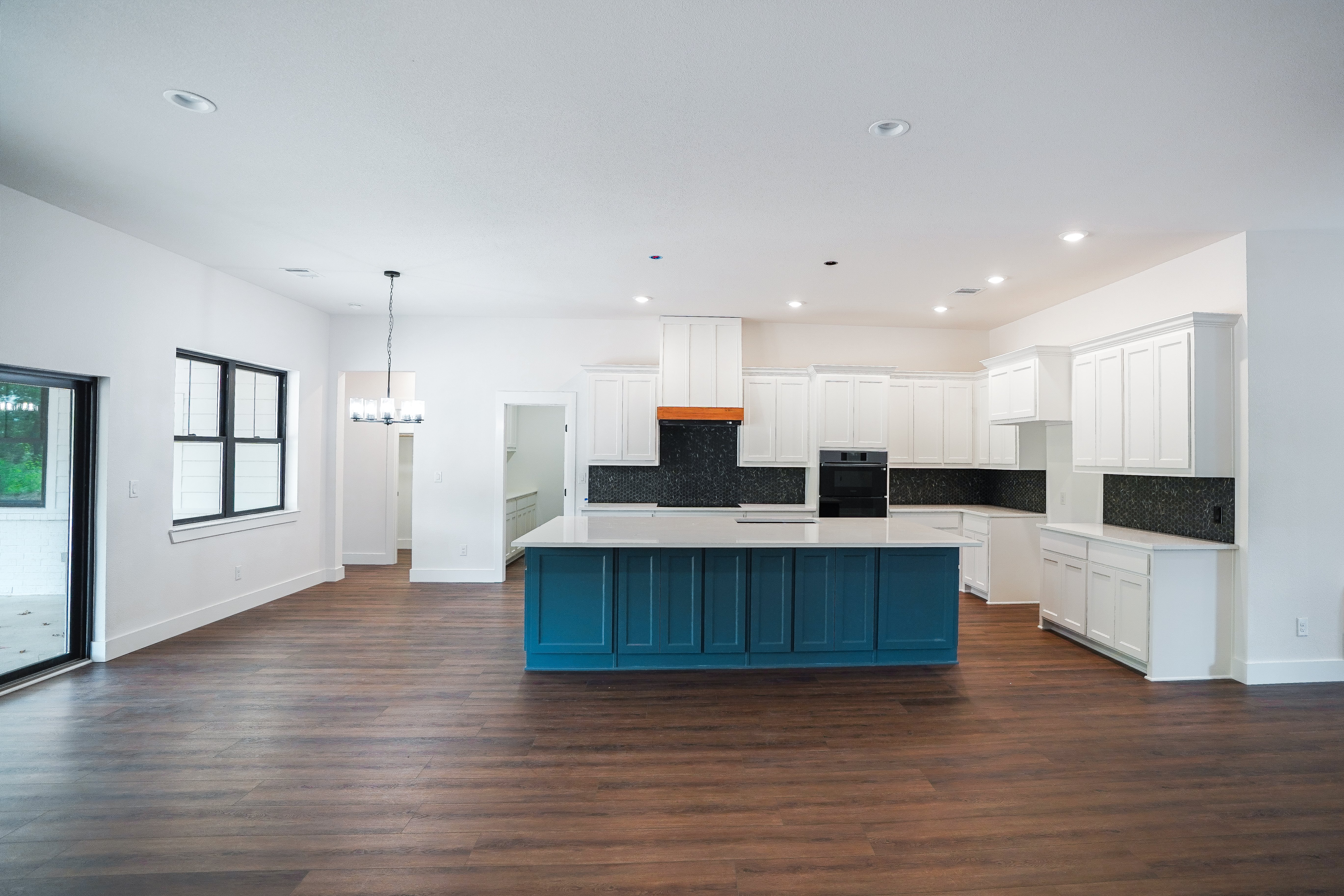 kitchen blue island black backsplash white cabinets
