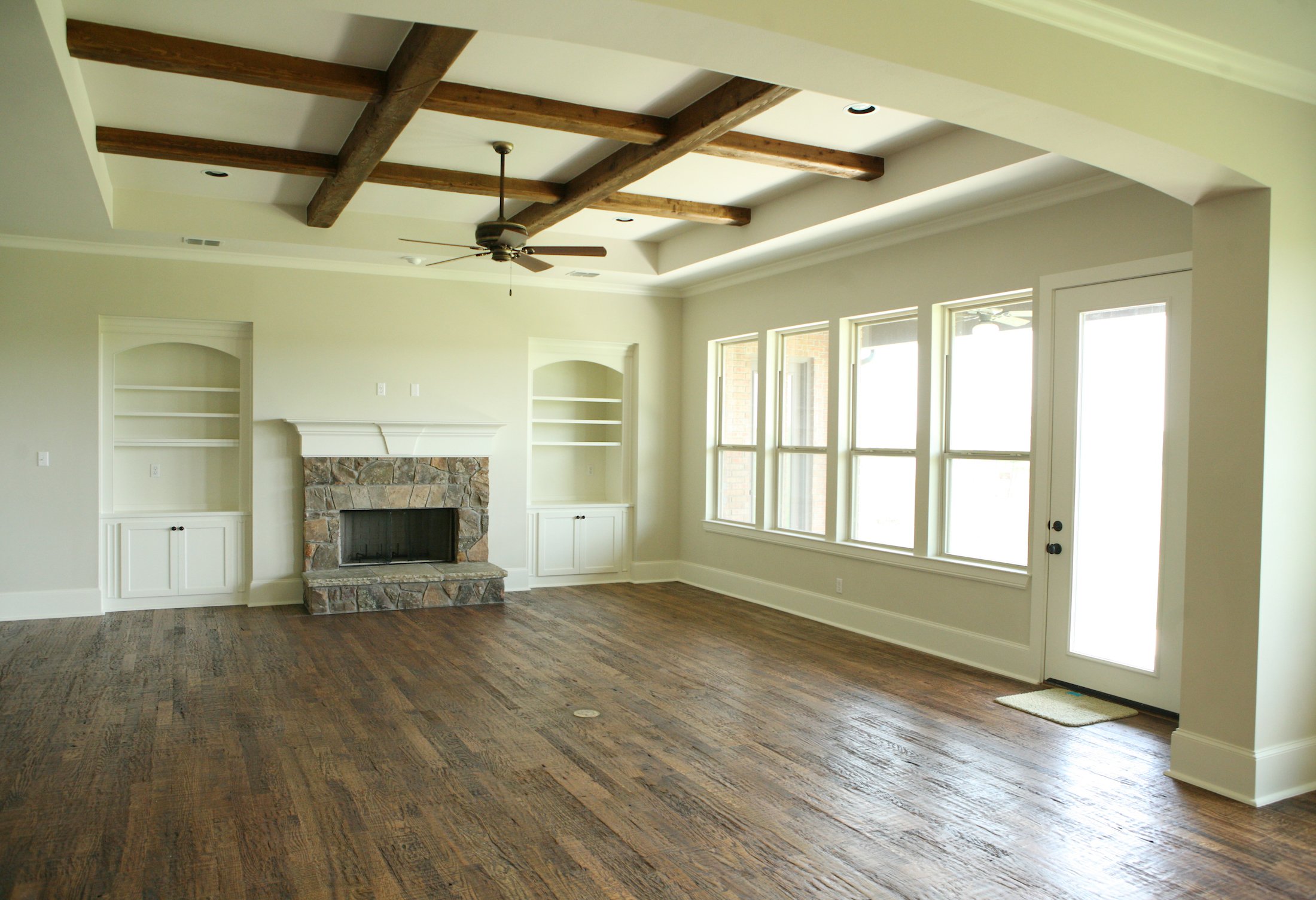 Living Room Design (Texas Homes): saddle creek family room with oak floors and beams and stone fireplace